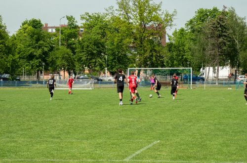 Amateur soccer players compete in a local match at a grassy field in Wrocław, Poland.