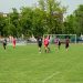 Amateur soccer players compete in a local match at a grassy field in Wrocław, Poland.